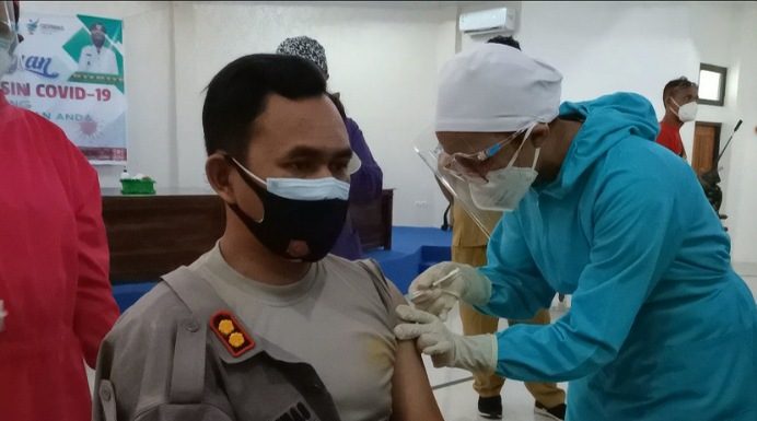 Pejabat Alor, Nakes dan Tokoh Agama Disuntik Vaksin Covid-19 Tahap I Kapolres Alor AKBP Agustinus Chrismas Try Suryanto disuntik Vaksin Covid-19 Tahap I, Senin (1/2/2021) di aula Gedung BPBD Alor, Kalabahi Kota.