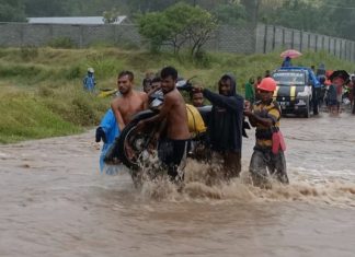 Banjir, Warga Alor Pikul Kenderaan Seberang Jalan Nasional Pemuda Desa Lembur sedang memikul kenderaan roda dua akibat banjir di jalan Nasional Kalabahi - Maritaing, Jumat (2/4/2021) siang.
