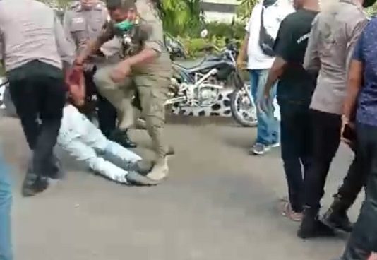 Sadis!! Polisi dan Sat Pol PP Pukul Injak Demonstran Saat Demo Tolak Relokasi Pasar di Alor NTT Gbr: Tangkapan layar video seorang oknum Anggota Polres Alor dan Pol PP diduga memukul dan menginjak demonstran mahasiswa yang berdemonstrasi menentang kebijakan pemerintah merelokasi 753 pedagang di Alor.