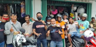 HUT PSI – 7, DPD PSI Alor bagi Nasi Kotak pada Masyarakat Ketua DPD PSI Alor Dony M. Mooy (tengah) dan Sekretaris DPD PSI Alor, Muhamad Supriadi Djae (ujung kiri) bersama pengurusnya, foto bersama para pedagang kaki lima dan ojek usai membagikan rice box di pasar Lipa, Kalabahi.