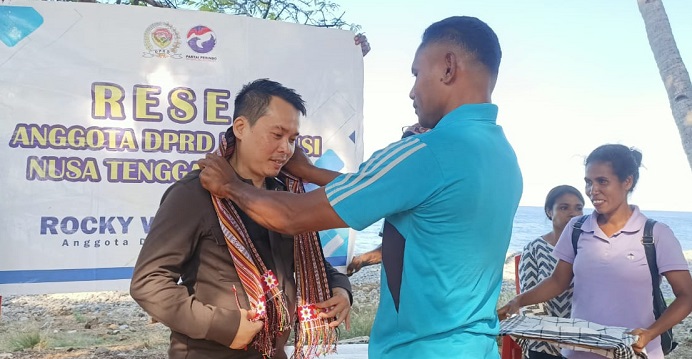 Kepala SMA Negeri Kolana Oscar Lobang, mengalungkan salendang kepada Rocky Winarya ketika tiba reses di sekolah itu, Rabu (13/7) di Kolana.