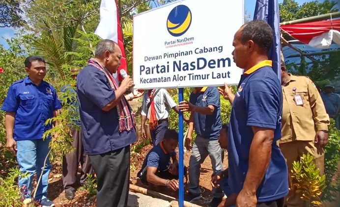 Ketua DPD NasDem Alor Dr. Imanuel E. Blegur (tengah) di dampingi Ketua OK Jhoni Tulimau (ujung kiri) memajangkan papan nama DPC Partai NasDem Kecamatan ATL di Pumai, Desa Nailang, Senin (8/8).