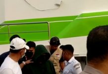 Polisi Tangkap Vikaris Gereja yang Perkosa 6 Anak di Alor Foto: Vikaris SAS (tengah jaket hitam tutup kepala) dikawal aparat Polres Alor setelah tiba di pelabuhan Kalabahi, Senin (5/9) sekitar pukul 17.00 WITA. (Foto: doc tribuanapos.net).