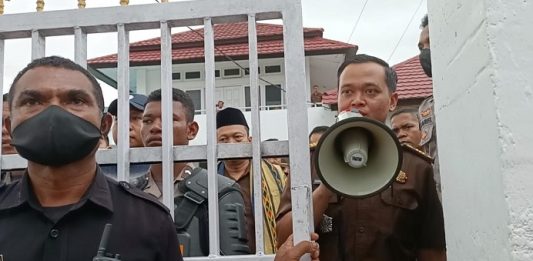 Pidanakan Aktivis Anti Korupsi dan Korban Bencana Seroja, Kajari Alor Abdul Muis Ali Didesak Mundur dari Jabatan Kasie Intel Kejari Alor Zakaria Sulistono (pegang megafon) sedang mengajak demonstran untuk berdialog dengan Kajari di aula kantor Kejaksaan, Selasa (4/4/2023). Nampak Kajari Abdul Muis Ali juga menghampiri demonstran di pintu gerbang kantor Kejaksaan dikawal ketat aparat kepolisian dan Satpam Kejaksaan.