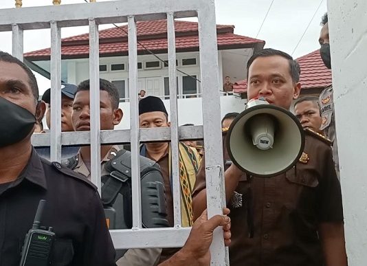 Pidanakan Aktivis Anti Korupsi dan Korban Bencana Seroja, Kajari Alor Abdul Muis Ali Didesak Mundur dari Jabatan Kasie Intel Kejari Alor Zakaria Sulistono (pegang megafon) sedang mengajak demonstran untuk berdialog dengan Kajari di aula kantor Kejaksaan, Selasa (4/4/2023). Nampak Kajari Abdul Muis Ali juga menghampiri demonstran di pintu gerbang kantor Kejaksaan dikawal ketat aparat kepolisian dan Satpam Kejaksaan.