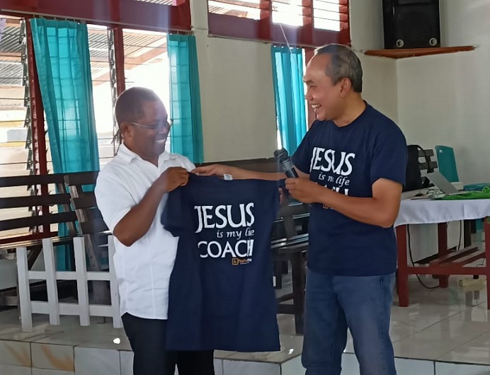 Dr. Pramudianto (kanan) memberikan baju kepada Dr. Fredik A. Kande sebelum memberikan materi pelatihan bagi para pendeta GMIT di Tribuana Alor.